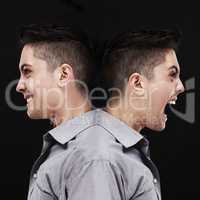 Split personality. Studio shot of a young man showing two sides of his personality.