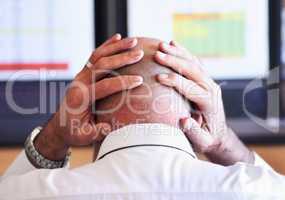 These figures are racking his brain. Rear view shot of a businessman looking stressful while placing his hands behind his head.