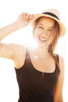 Remember your sunscreen. A playful young woman holding her hat in bright sunlight.