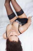 Sensuous young female in lingerie lying playfully in bed. Sensuous young female in lingerie lying playfully in bed.