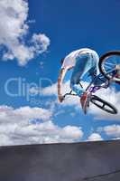 Practicing for the x games. Rearview shot of a teenage boy riding a BMX at a skatepark.
