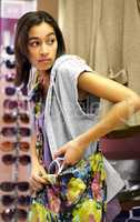 The shoplifter sale is on. Cropped shot of a young woman sneaking stolen clothing into her handbag.