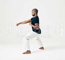 Learning is a gift even if pain is your teacher. Studio shot of a young martial artist practicing.