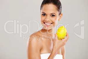 Vitamin C is a great nutrient for the skin. Cropped portrait of a smiling woman holding up a fresh lemon - isolated.