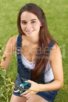 She enjoys gardening. Portrait of a beautiful young woman pruning her hedges.