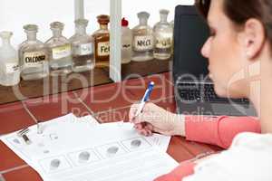 Theyre a match. Shot of a forensic scientist writing up a ballistics report.