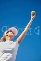 Acing her opponent. A young tennis player serving during a match.