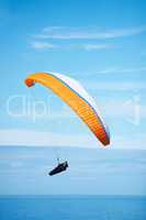 Wings over water. Shot of a man paragliding on a sunny day.