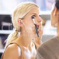 To a make-up artist, every face is a canvas. Pretty young woman having her makeup applied by a stylist.
