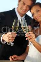 Heres to us. Cropped view of a young bride and groom standing together and toasting their marriage.