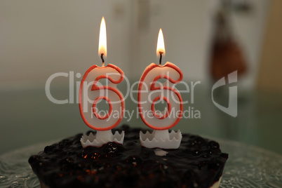 Birthday cake with burning candle number 66