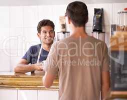 Best cuppa joe in town. A man buying a cup of coffee at a coffee shop.