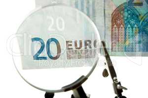 Checking every euro. Shot of a 20 euro bill under a magnifying glass.