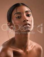 My lungs were riddled with our fears. Portrait of a beautiful young woman posing against a brown background.