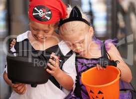 Childhood disappointments. A brother and sister sulk together and look at their empty sweet baskets on halloween.