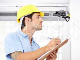 Contracted to secure your home. Shot of a handsome young man installing a security camera.