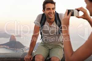 Capturing a memory. A young tourist having his picture taking while backpacking.