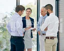 They empower each other. Shot of a group of colleagues working on a digital tablet in an office.