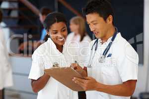 Helping others to get better is our goal. Shot of two doctors dicussing patient diagnosis.