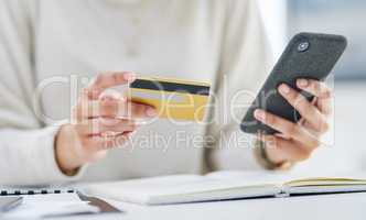 Online shopping platforms are so easy to use. Closeup shot of an unrecognisable businesswoman using a cellphone and credit card in an office.