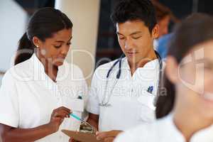 I can give you a few tips on this treatment. Shot of two medical professionals discussing a document.
