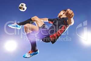 Hes got game. Shot of a young footballer kicking a ball in mid-air.