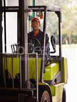 Men at work. A worker operating a forklift indoors.