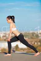 Calm morning workout. Shot of an attractive young woman in workout gear doing yoga on a rooftop.