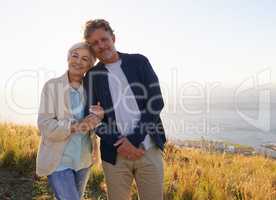 Committed to loving one another. View of a senior couple standing on a hillside together.