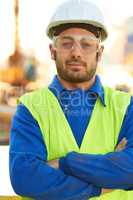 Professional - Hell get the job done. A stern construction working wearing protective glasses and crossing his arms.