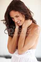 Celebrating femininity. A happy semi-nude woman holding her neck and smiling.