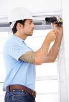 Securing your home as if it were his own. Shot of a handsome young man installing a security camera.