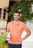 Hes a talented young architect. A handsome young architect standing and holding plans with a smile.