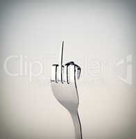 Fork you. A fork showing a rude gesture while isolated on grey.