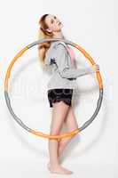 Holding her hula hoop. A gorgeous young woman holding a hula hoop in a studio shoot.