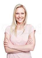 Pretty in pink. A pretty caucasian woman smiling at the camera with her arms crossed against a white background.