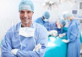 I have a team of surgical experts behind me. Portrait of a happy, confident and professional doctor with his team of surgical experts behind him.