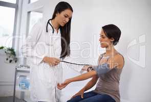 Feeling a little performance pressure. Shot of a young woman getting her blood pressure tested by a doctor.