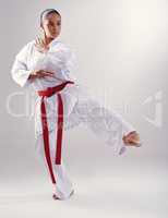 Shes got a solid kick. Shot of a young woman doing karate.