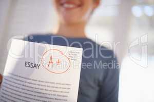 Easy A. Shot of a proud young boy holding up his essay that got him an A+.