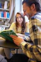 Fascinated by his knowledge. Shot of a young man and woman reading together.