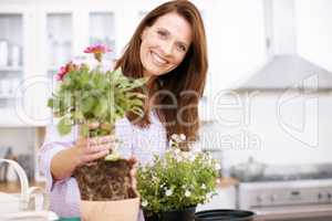 See how easy this is. Portrait of a beautiful woman potting some plants for summer.