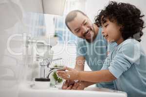 Now youll feel extra fresh. Shot of a father helping his son wash his hands and face at a tap in a bathroom at home.