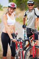 They love living active lives. Portrait of a healthy sporting couple going for a bike ride together.