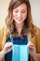 Time to spoil yourself. Cropped shot of an attractive young woman looking happily into a shopping bag.