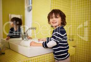 This is how Mom showed me to do it. A cute little boy washing his hands in the bathroom basin.