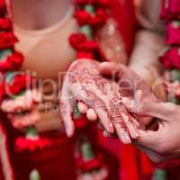 This ring is a token of my love. Cropped shot of a hindu couple exchanging rings on their wedding day.