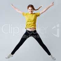 Star jumps. Full-length studio shot of a beautiful young woman doing a star jump.
