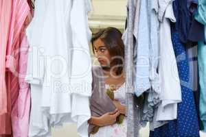 Nobodys watching.... Young woman trying to steal a garment from a store.