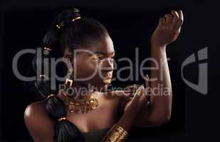 Shes the epitome of a true black queen. Studio shot of a beautiful young woman wearing make up and jewellery against a black background.